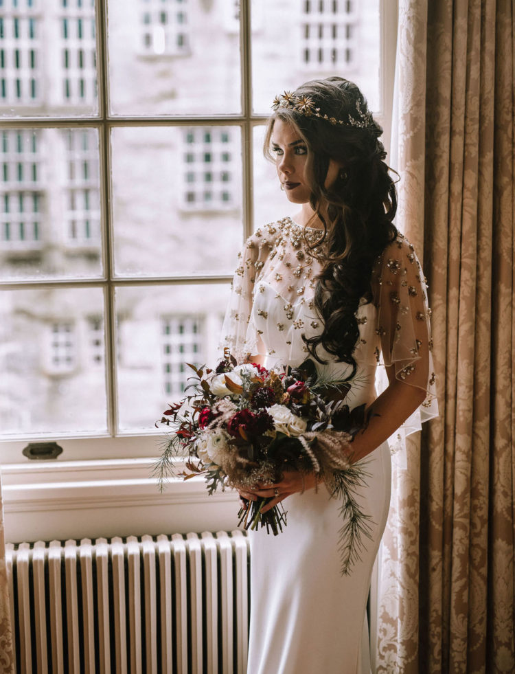 The bride was wearing a fitting modern wedding gown with an embellished shawl, long wavy hair and a dark lip