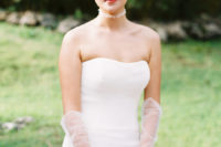 03 The bride was wearing a modern strapless fitting wedding dress, an airy choker with pearls, tulle gloves and earrings