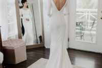 03 a chic modern wedding gown with a V-neckline and a cutout back on buttons, long sleeves and a train