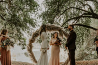 05 The wedding ceremony space was done with a trendy wreath wedding arch of pampas grass and boho rugs