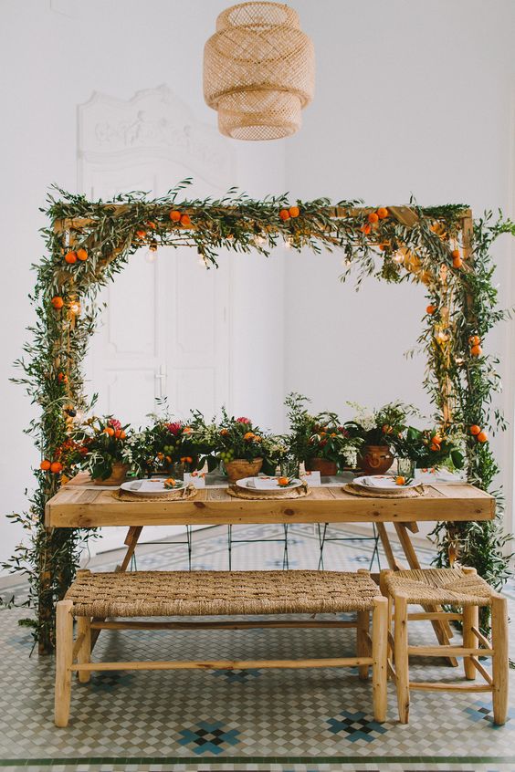 a bright and creative reception space done with potted plants and citrus and an overhead decoration