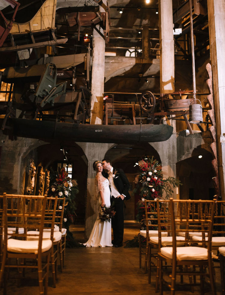 The wedding ceremony took place in the museum hall, with lush florals and evergreens