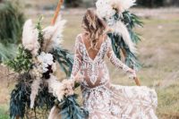 08 a boho chic triangular wedding arch decorated with pampas grass, greenery and lush florals