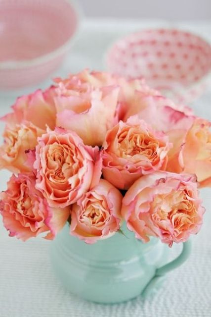 a wedding centerpiece of a mint vase and coral blooms is a bright and trendy idea that can be DIYed