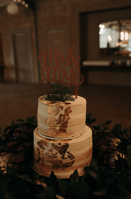 The wedding cake was a naked one decorated with gold leaf, herbs and a calligraphy topper