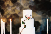 super modern all-white wedding cake with a bloom