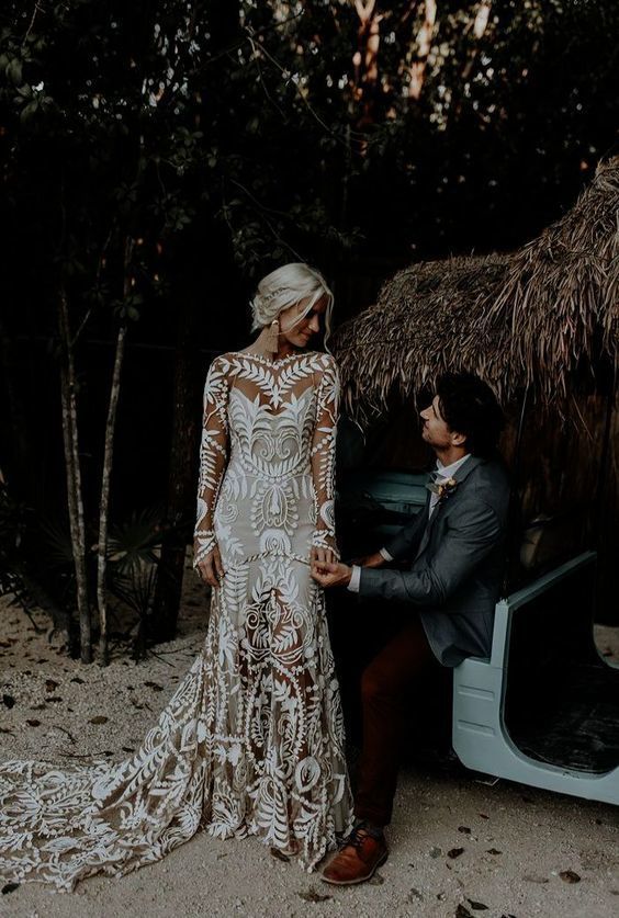 a super romantic boho lace wedding gown with a train and long sleeves