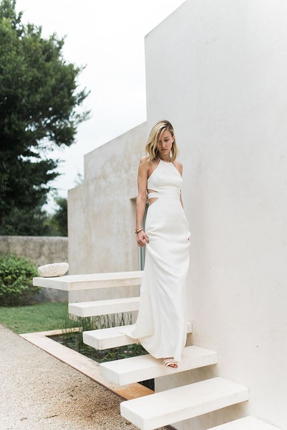 a halter neckline wedding dress with side cutouts and a strappy back, simple accessories and loose hair