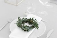 16 a modern winter wedding tablescape with a little greenery wreath, all white everything and some candles