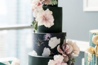 18 a dramatic wedding cake with several black tiers and a single floral one, sugar blooms for decor that match hand painting
