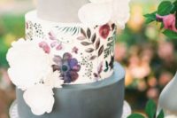 19 a modern wedding cake with two grey tiers and a floral painted tier in the center plus white sugar blooms