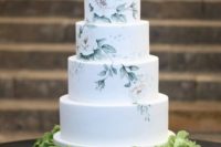 20 a beautiful and neutral handpainted wedding cake with several floral tiers and a white one plus a hydrangea pillow