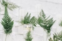 20 candles spruced up with ferns are a great idea to add a fresh touch to your minimalist Nordic wedding
