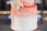 23 a watercolor brushstroke wedding cake in white and coral with gold leaf dots and a sugar flowers