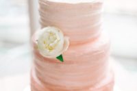 25 an ombre coral wedding cake with a pink letter topper and a single fresh bloom for a subtle color touch