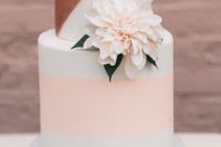 26 a white wedding cake with a peachy pink stripe and copper geometric decor plus a blush bloom