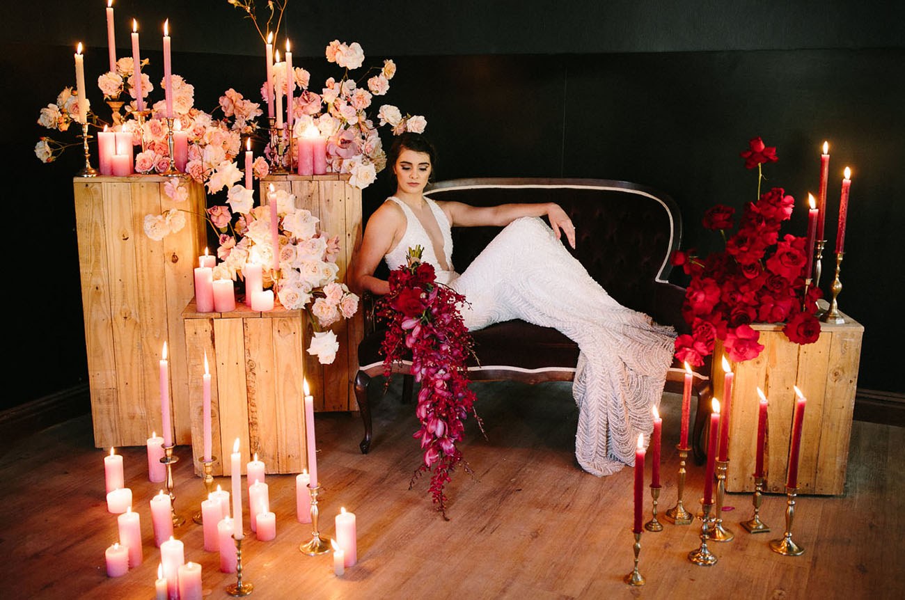 The wedding lounge was styled with pink and red blooms and lots of candles plus a velvet coach