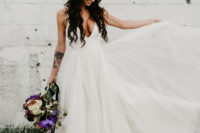 03 The bride was wearing a minimalist wedding dress with a sleek top with a plunging neckline and a layered skirt plus ears