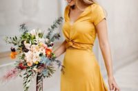 03 a beautiful gold yellow maxi dress with short sleeves, a V-neckline and a tied detail on the waist