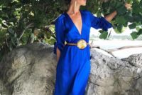 03 a fantastic bright blue maxi gown with a plunging neckline, long sleeves, statement earrings and a belt