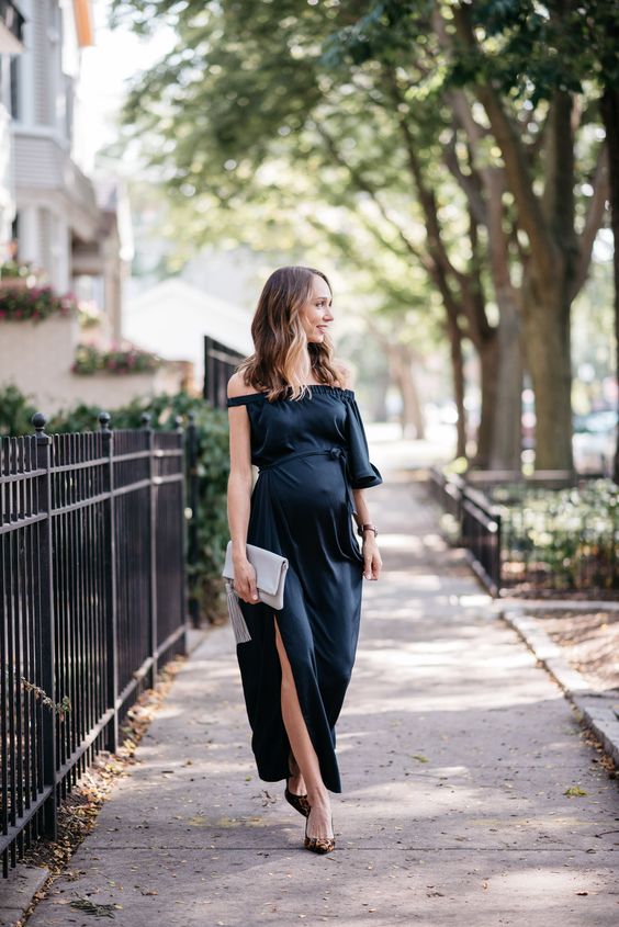 a black off the shoulder maxi dress with a single bell sleeve and a side slit, a grey tassel clutch and leopard shoes
