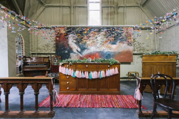 The ceremony space was done with a watercolor artwork, colorful tassels and lots of colorful paper cranes