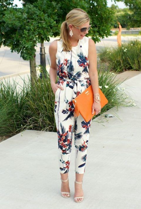 a tropical print sleeveless jumpsuit with cropped pants, nude heels and an orange clutch for a modern feel