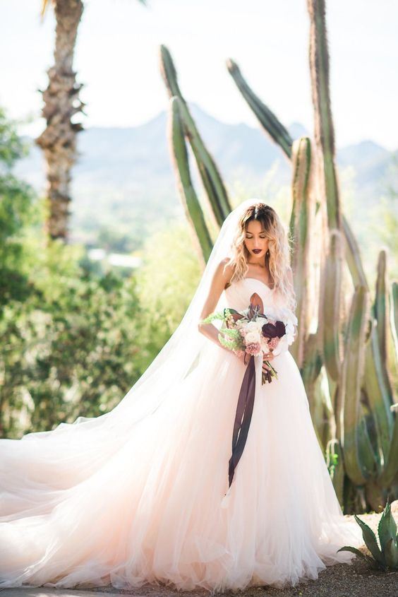 a blush strapless ballgown with a long train and a layered skirt for a dreamy look
