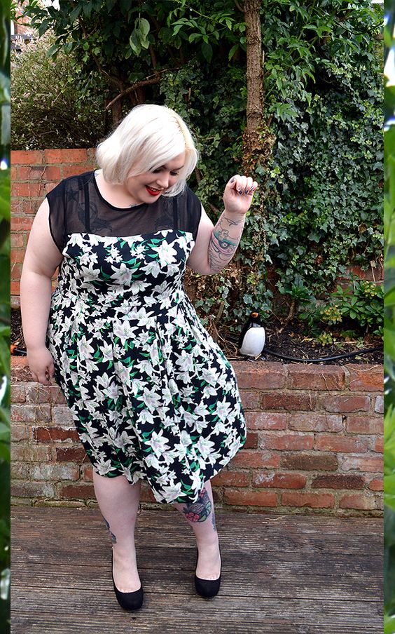 a floral midi dress with a sheer black top, black shoes for a stylish spring or summer wedding guest look