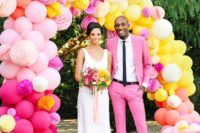 08 a super colorful wedding arch composed of pink, blush, yellow and orange balloons and paper balls
