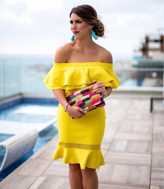 an off the shoulder neon yellow knee dress, a colorful clutch, blue tassel earrings