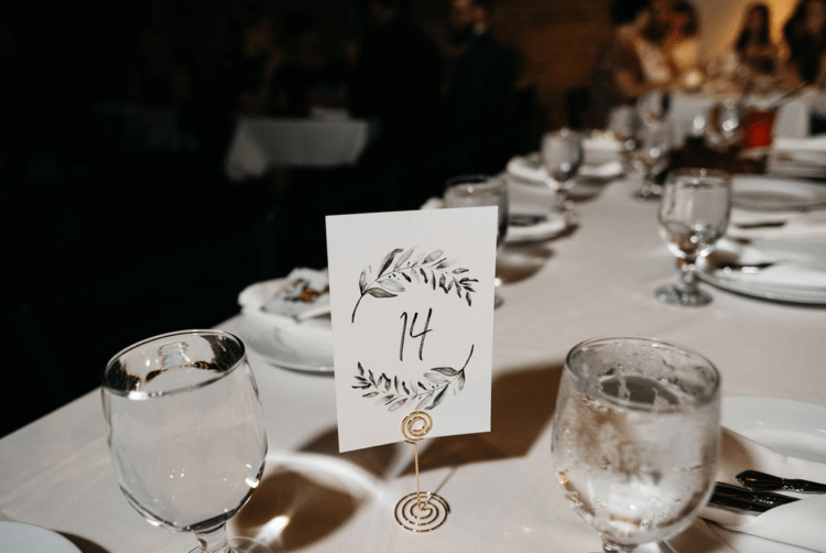 The wedding table settings were neutral and simple, with handpainted table numbers