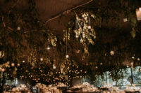 09 The wedding venue was decorated with lush greenery and branches and hanging lights