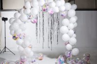 09 a white balloon wedding arch with sheer ones filled with colored paper and silver rain hanging down