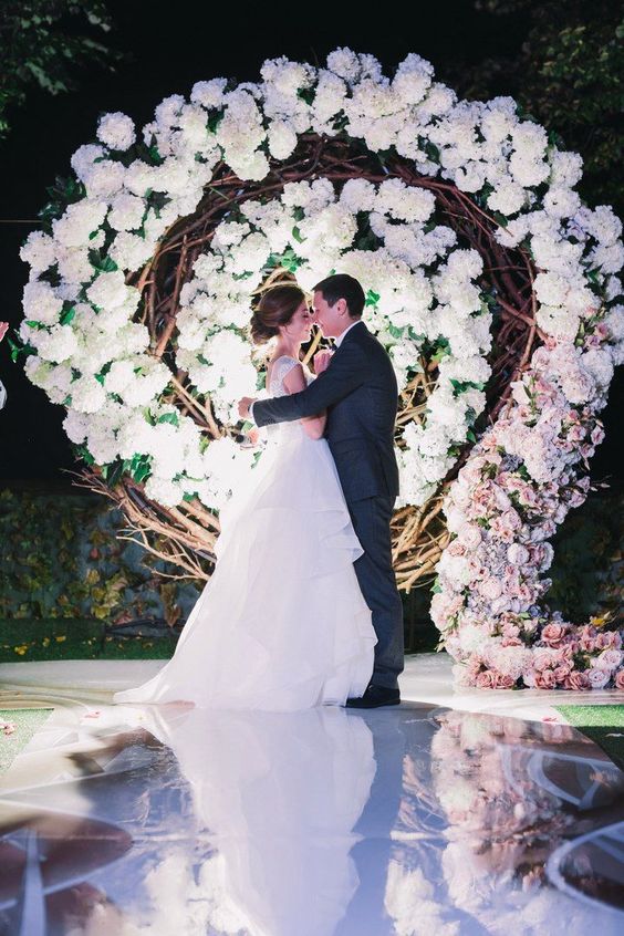 a white rose spiral floral backdrop for a glamorous wedding is a chic idea to rock