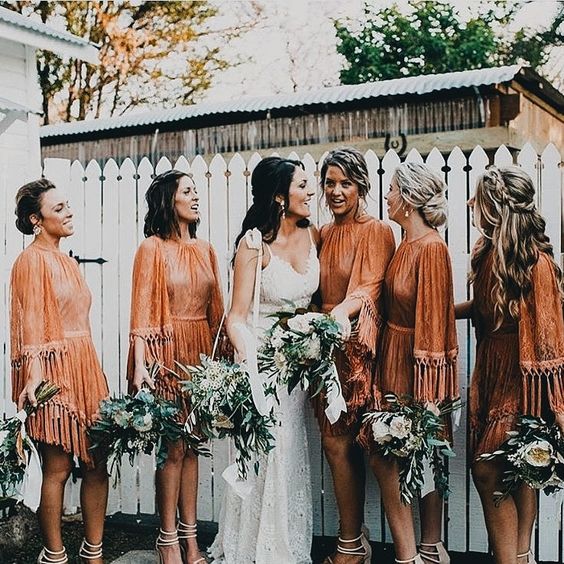 rust mini dresses with long fringed sleeves, high necklines and asymmetrical skirts for a boho wedding