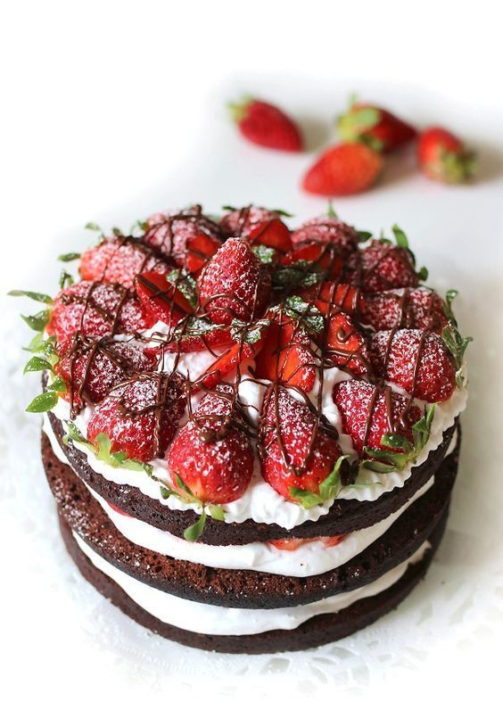 a vegan naked wedding cake with fresh strawberries, chocolate and vegan whipped cream