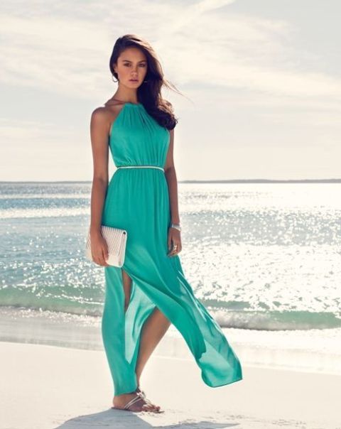 turquoise maxi dress with a halter neckline, side slits, sandals and a small white clutch