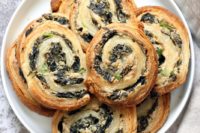 12 vegan spinach cream cheese pinwheels are puff pastry, rolled, sliced and baked to make a great snack