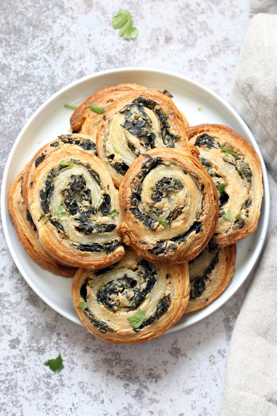 vegan spinach cream cheese pinwheels are puff pastry, rolled, sliced and baked to make a great snack