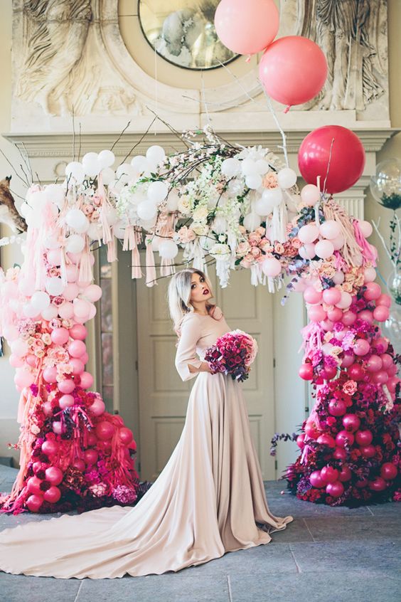 a bold ombre balloon, bloom and tassel wedding arch will make a gorgeous trendy statement in your ceremony space