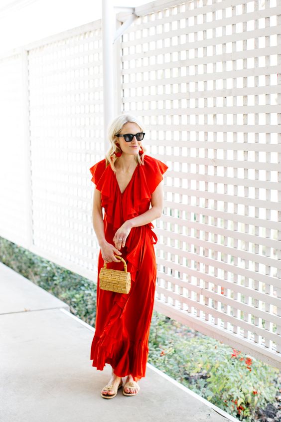 a red wrap ruffled maxi dress with cap sleeves, a small wicker bag and embellished sandals
