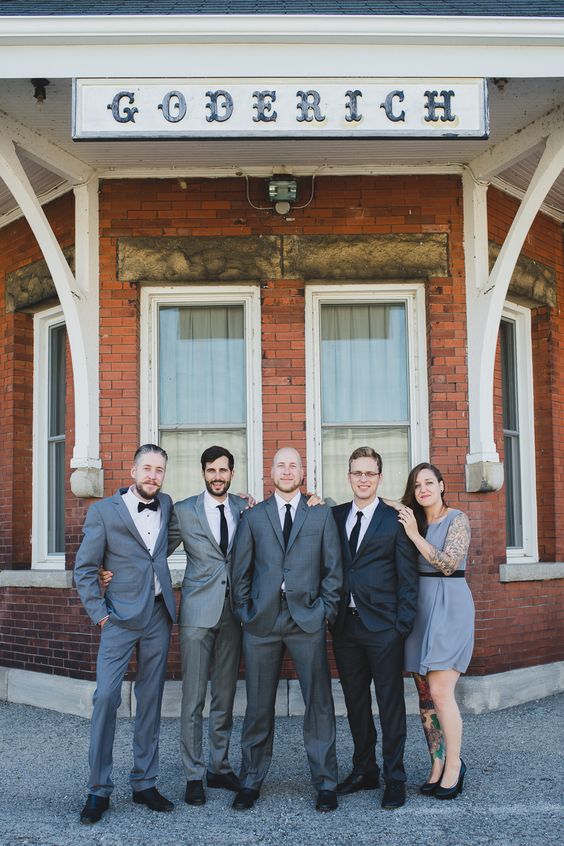 groomsmen wearign grey suits and a groomswoman rocking a grey dress and black heels