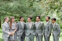17 groomsmen wearing grey suits and a groomswoman rocking a grey over the knee dress with a lace top