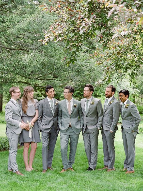 groomsmen wearing grey suits and a groomswoman rocking a grey over the knee dress with a lace top