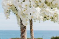 17 if you are having a tropical wedding, decorating your arch with lush white blooms may be a very cool idea