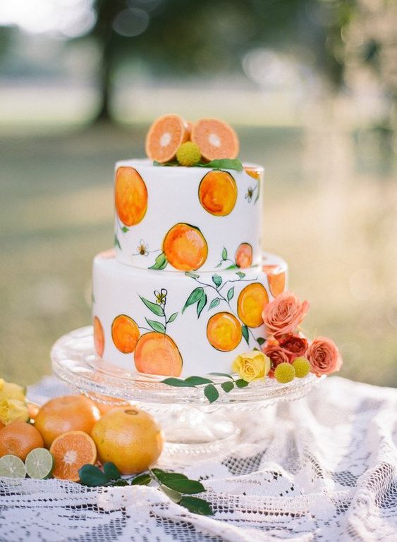 a cute handpainted wedding cake with painted and fresh fruits on top is a fun idea for a summer wedding