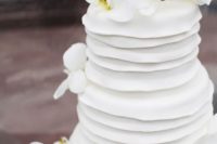 18 a white textural wedding cake topped with fresh white orchids is a catchy piece