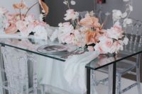 20 a modern wedding reception table of glass with pink roses, white orchids and coral anthurium floral decor