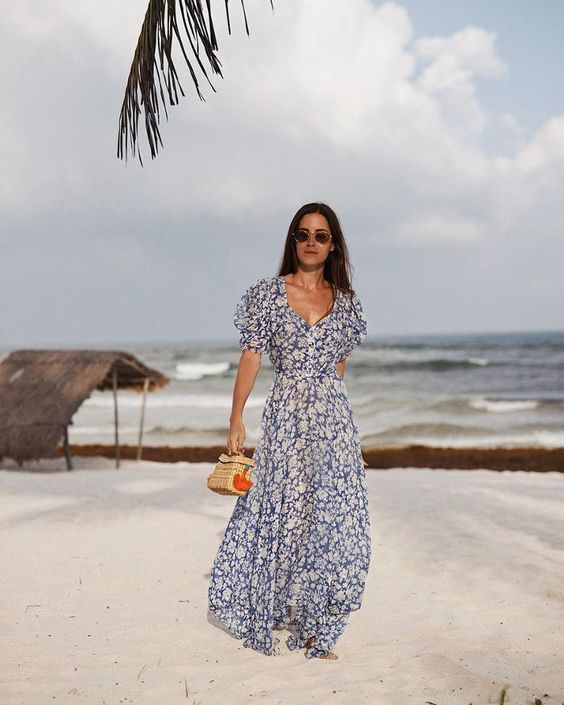 a gorgeous navy and white floral maxi gown with a deep neckline and short sleeves plus a small wicker bag